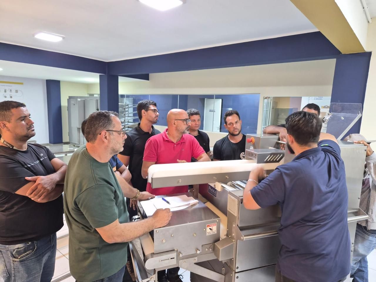 Grupo de homens observando máquinas em uma sala