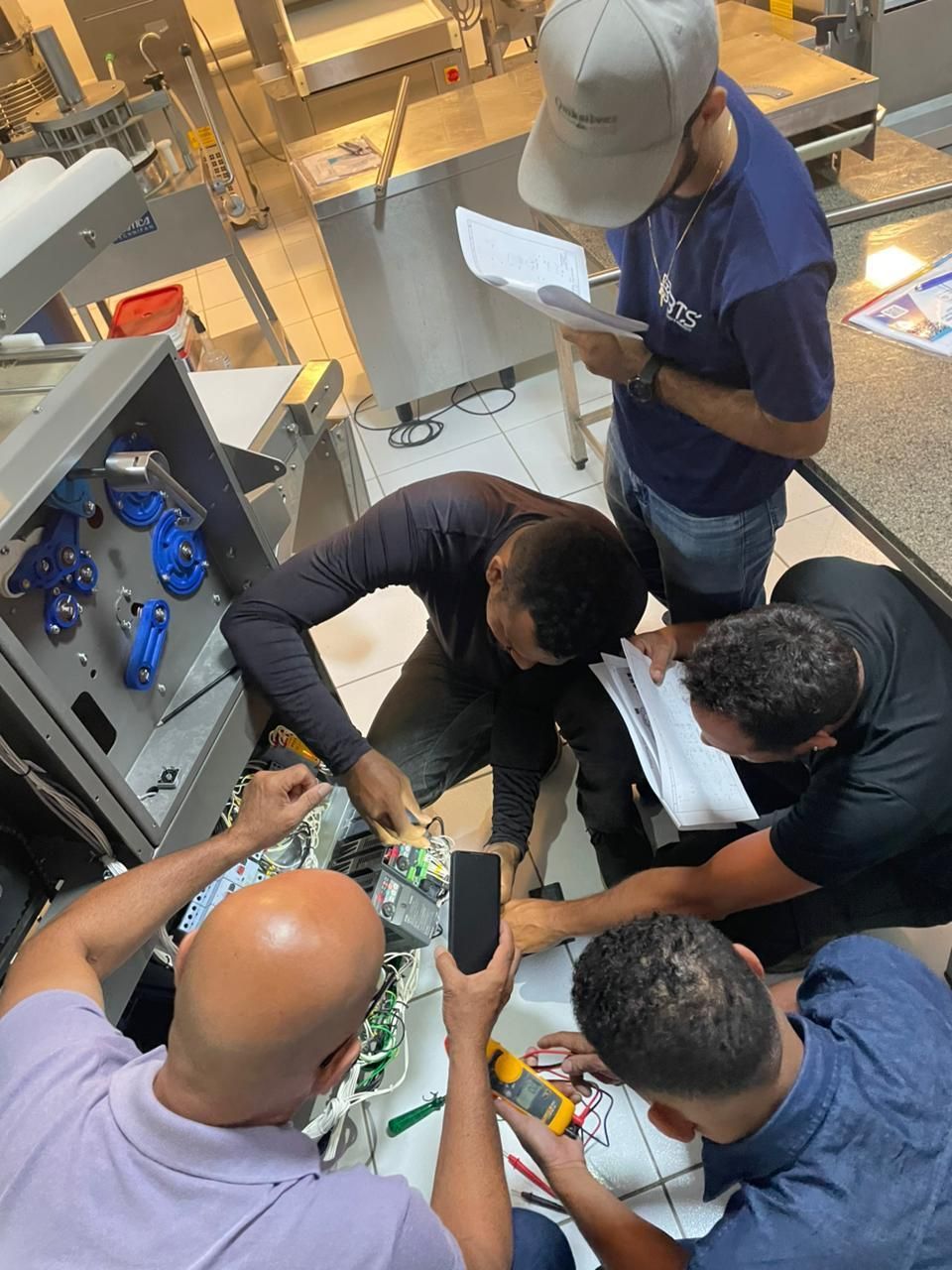 Grupo de pessoas trabalhando em equipamentos elétricos