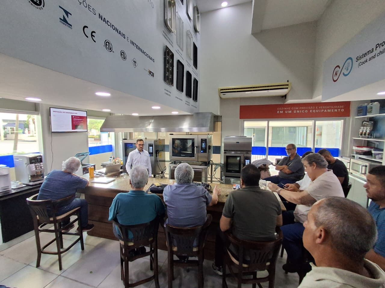 Um homem faz uma apresentação para um grupo sentado em um bar