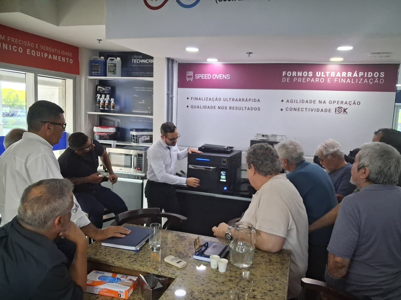 Um homem demonstra um equipamento para um grupo