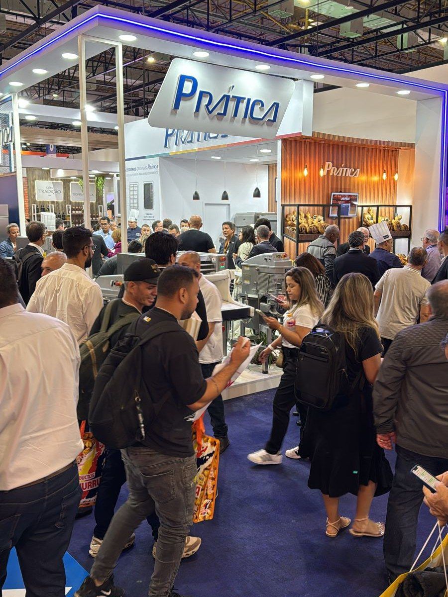 Um grupo de pessoas está em volta de um estande em uma convenção.