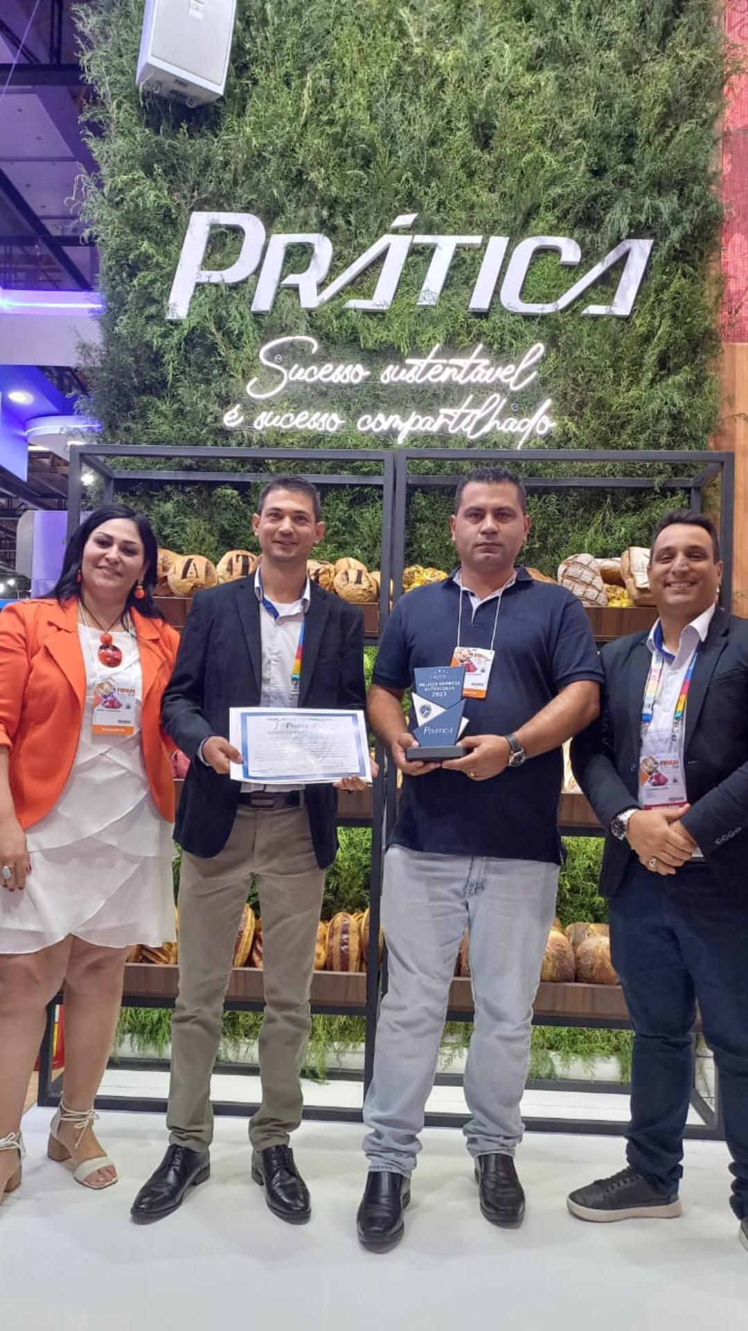 Um grupo de pessoas está próximo um do outro em frente a uma parede segurando um certificado.