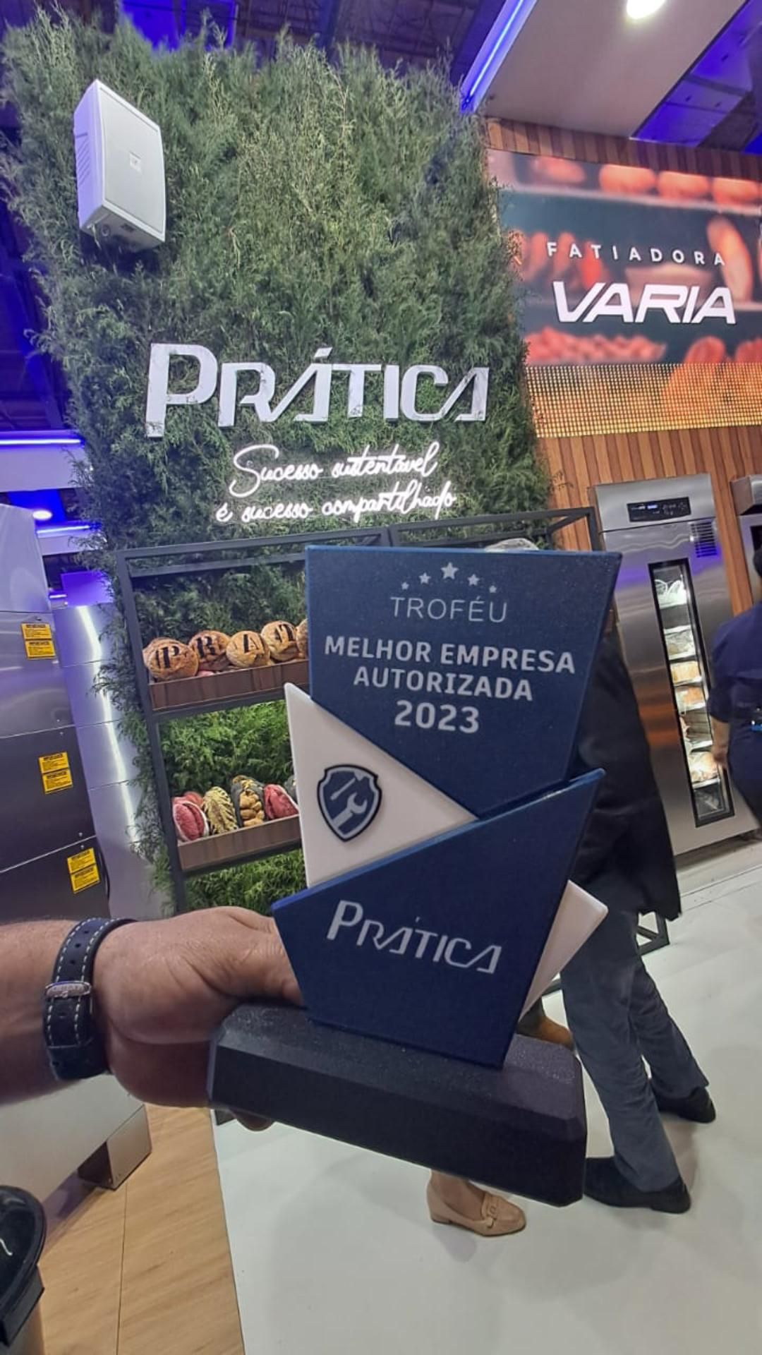 Uma pessoa está segurando um troféu na mão.