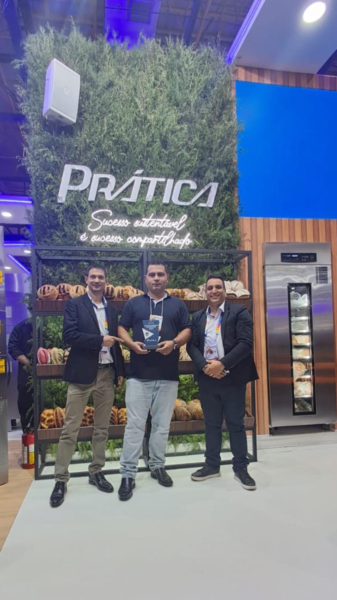 Um grupo de homens está parado um ao lado do outro em frente a uma vitrine de frutas e vegetais.