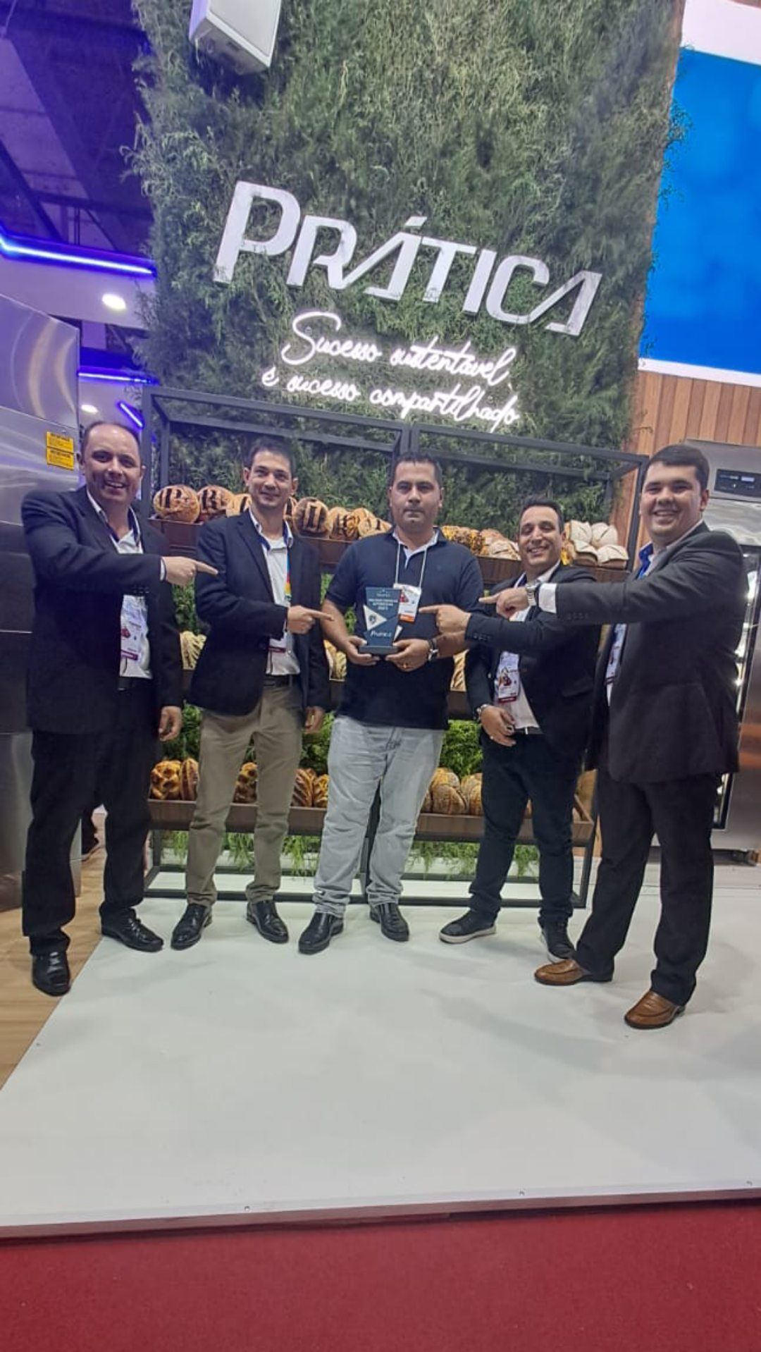 Um grupo de homens está parado um ao lado do outro em frente a uma placa.