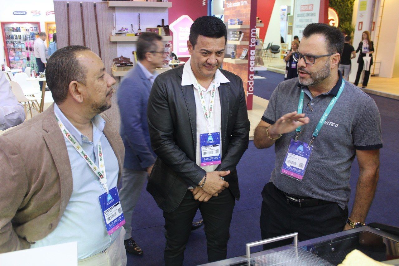 Um grupo de homens está em volta de uma mesa conversando entre si.