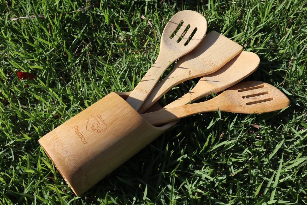 Um conjunto de utensílios de madeira em um suporte de madeira na grama