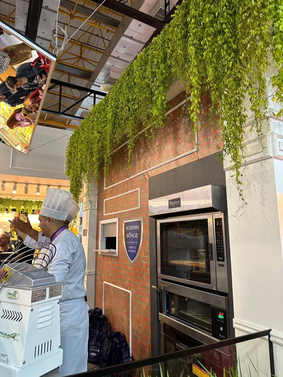 Um chef está em frente a um grande forno em uma cozinha.