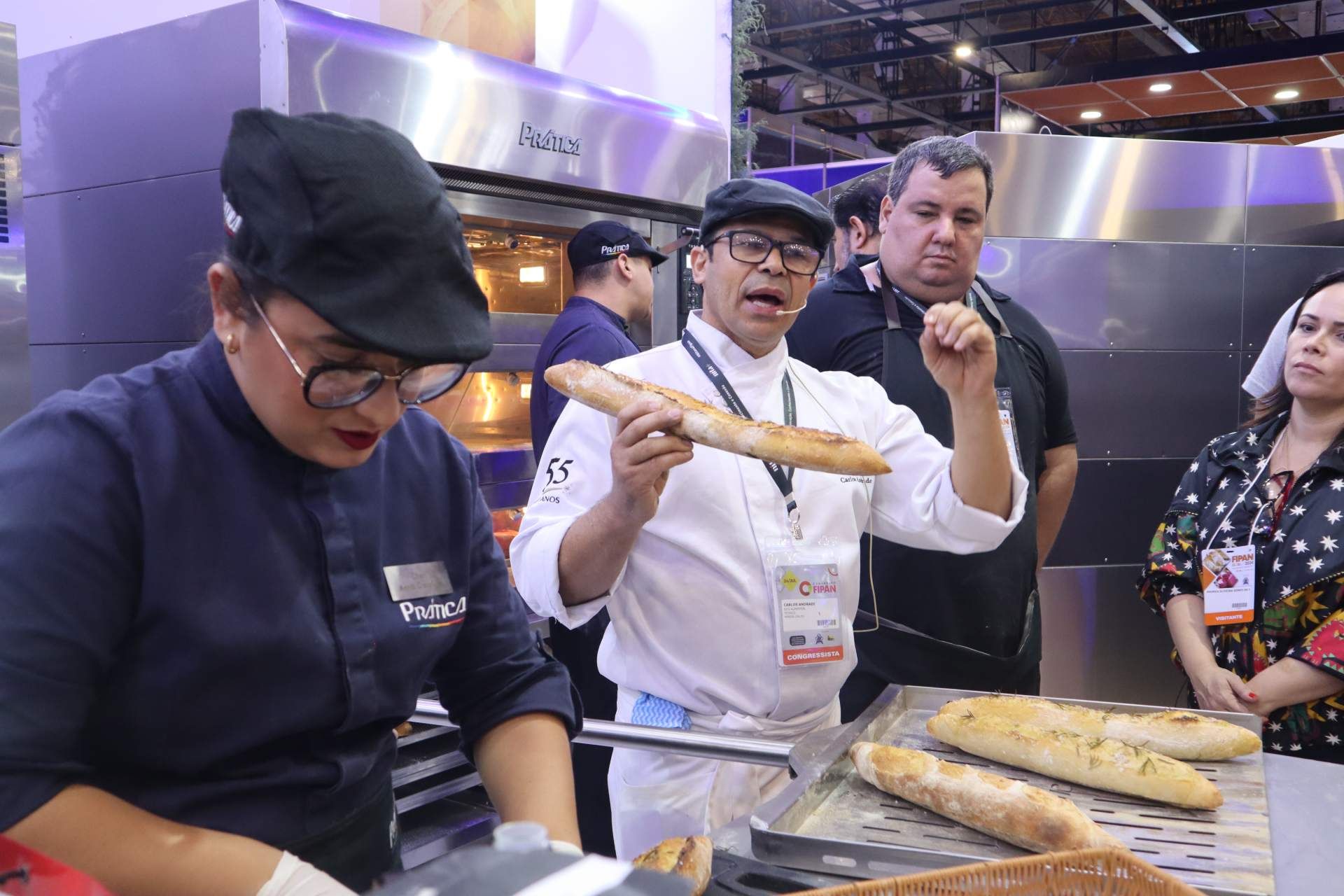 Um homem está segurando um pedaço de pão na frente de um grupo de pessoas.