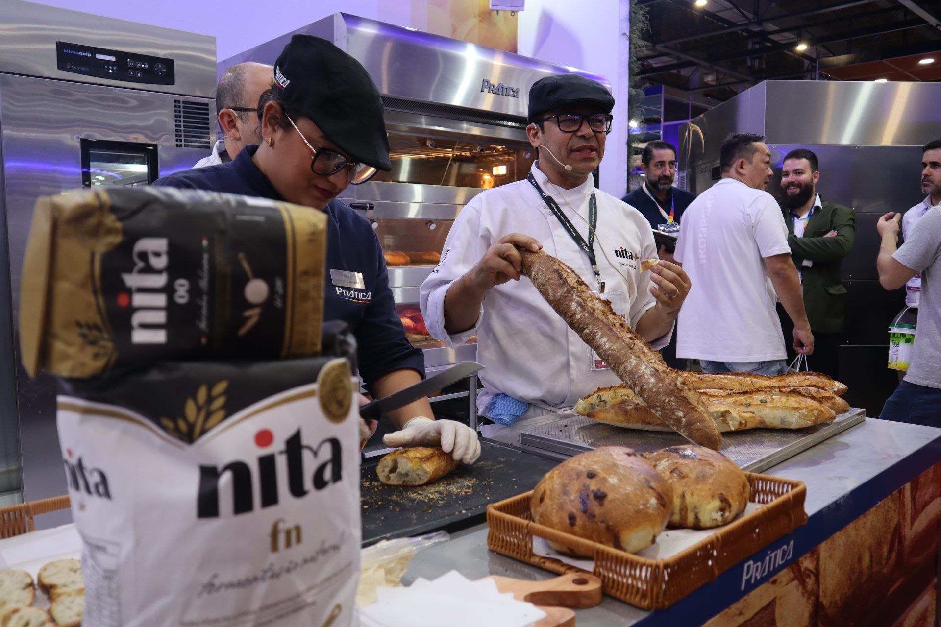 Um homem está segurando um pão na frente de um saco de farinha de nita.