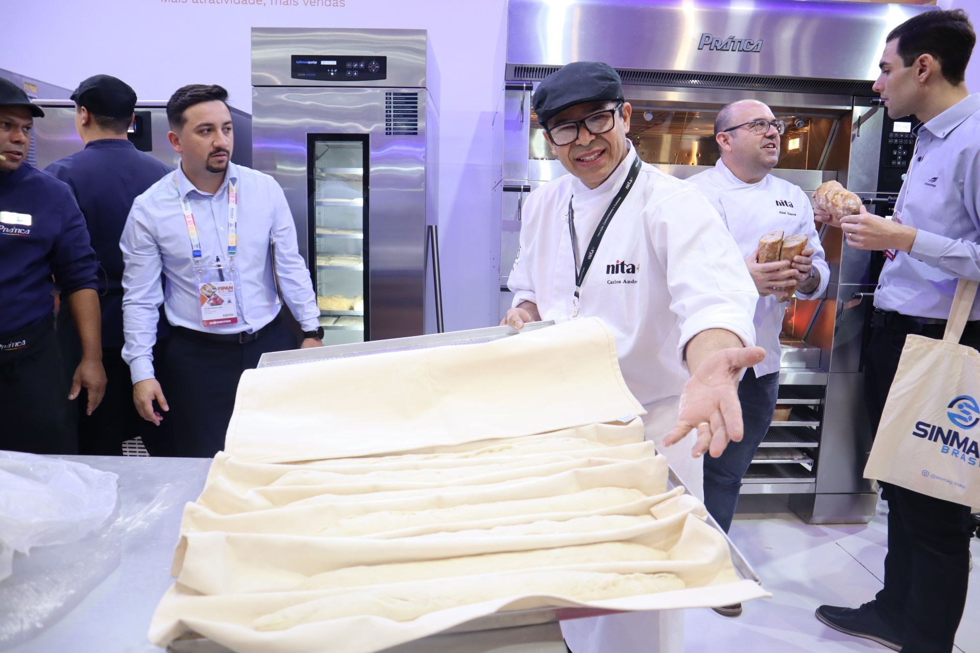 Um homem está de pé ao lado de uma grande pilha de massa.