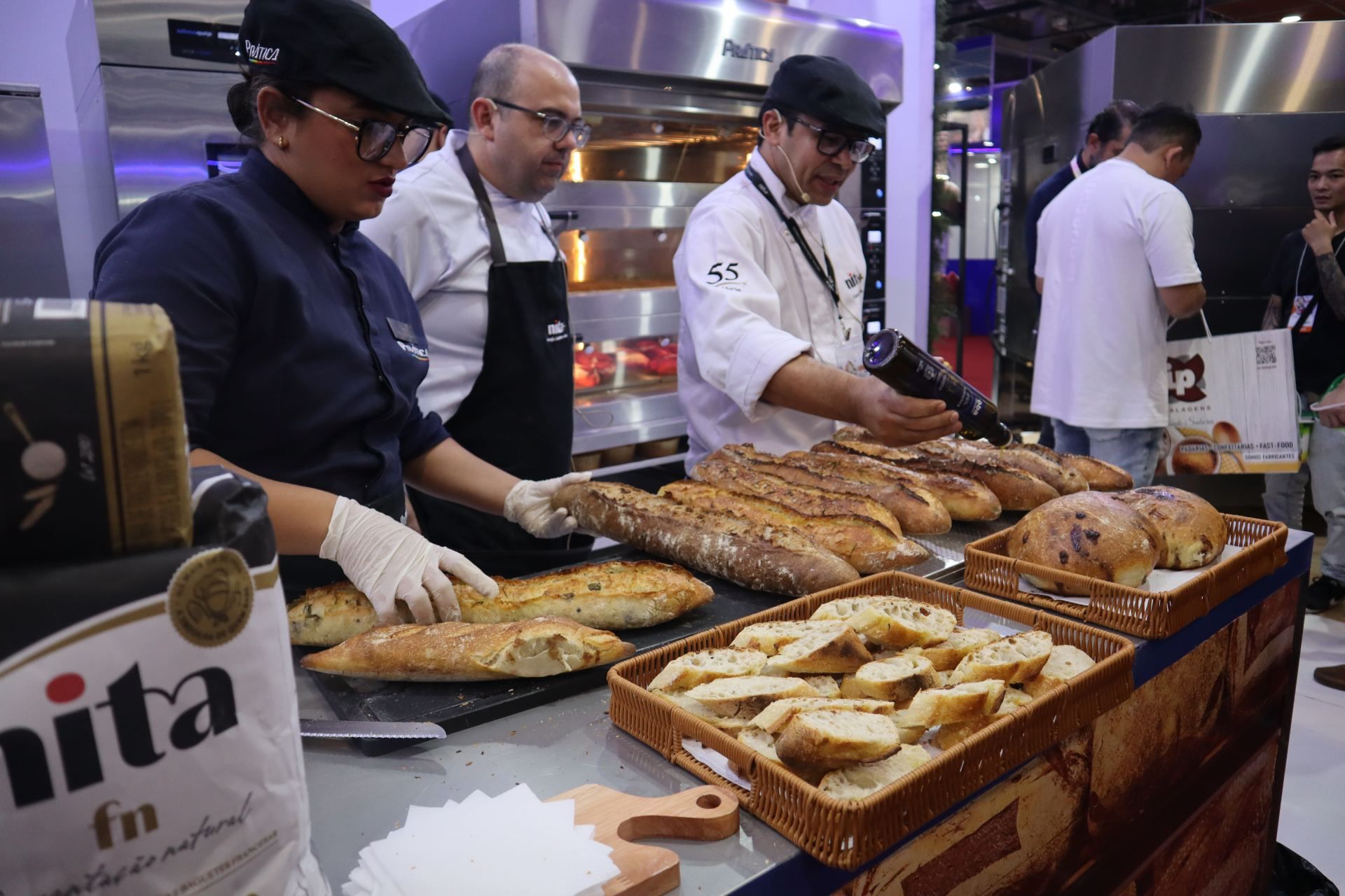 Um grupo de homens está preparando pão em uma padaria.