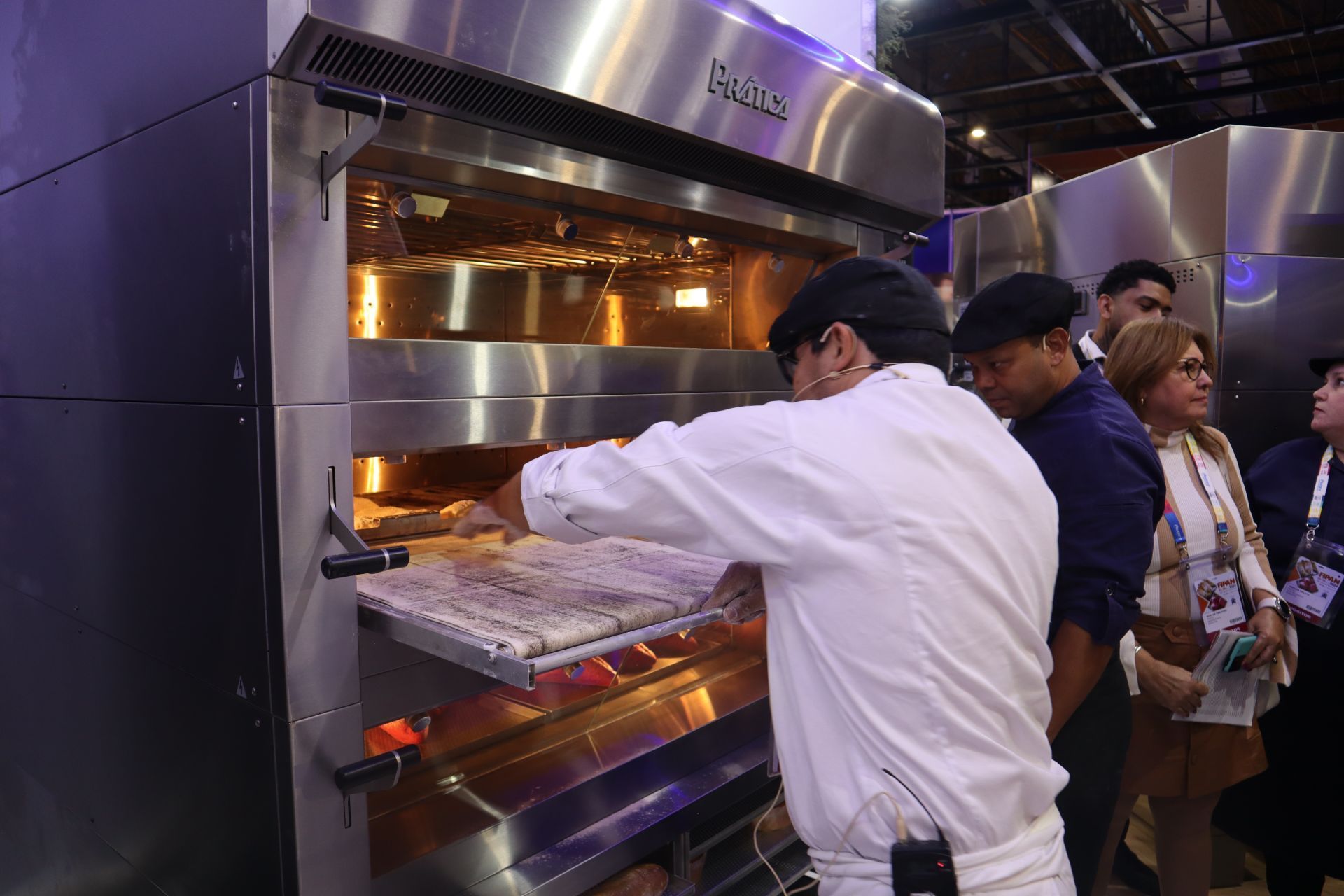 Um homem está tirando uma pizza do forno.