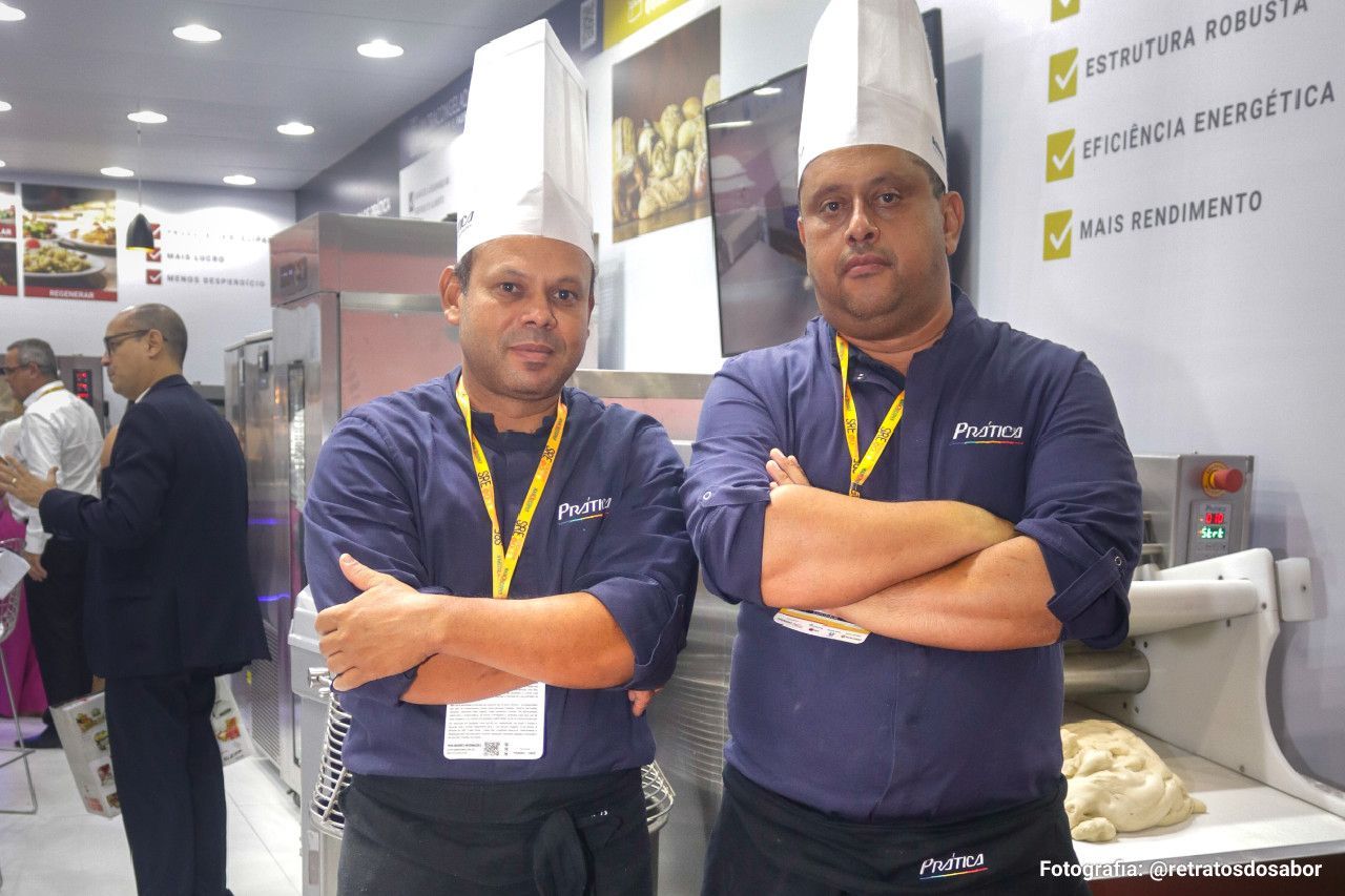 Dois homens de pé um ao lado do outro com os braços cruzados