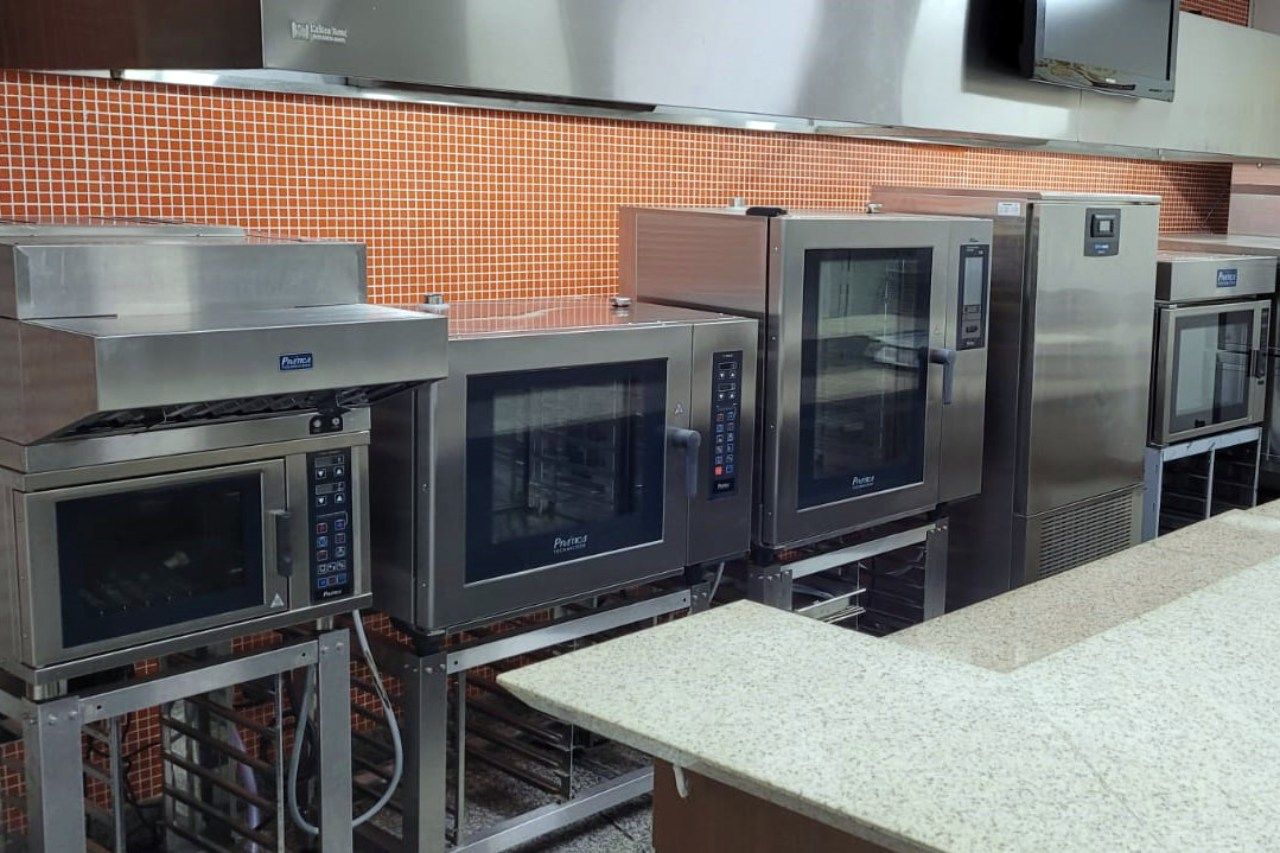 Uma cozinha com muitos eletrodomésticos de aço inoxidável e um balcão.