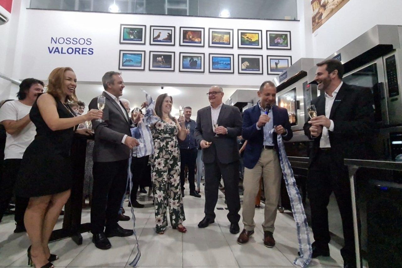 Um grupo de pessoas em pé em frente a uma parede que diz nossos valores