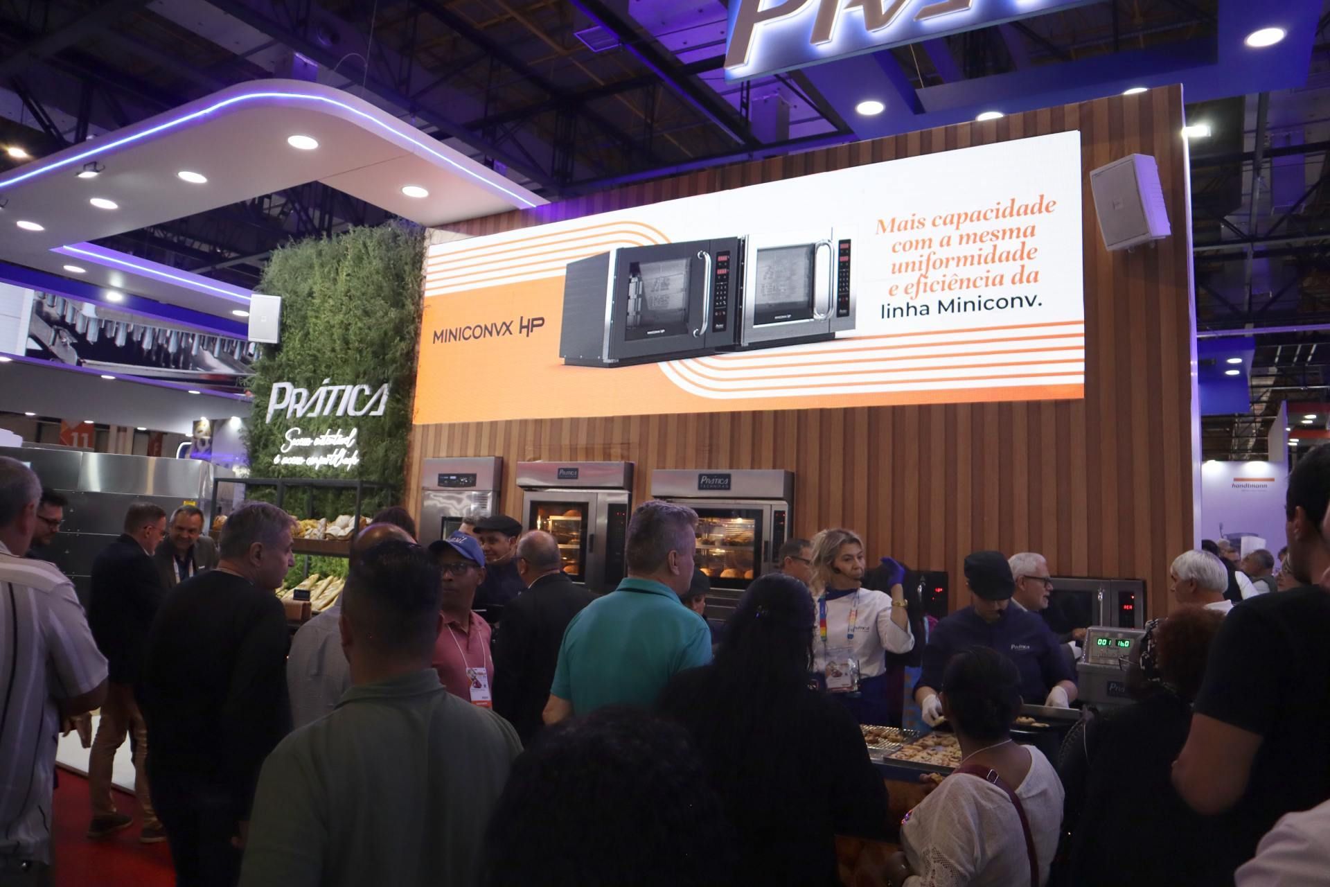 Um grupo de pessoas está em pé em frente a uma tela grande.