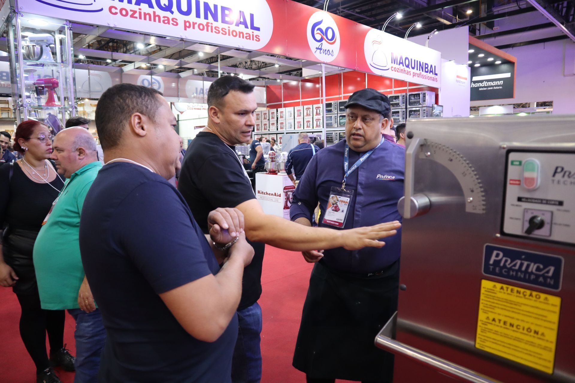 Um grupo de homens está em volta de uma máquina em uma convenção.