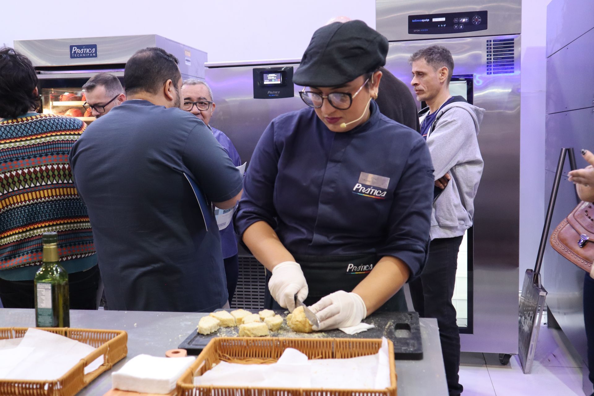 Uma mulher com uniforme de chef está preparando comida na cozinha.