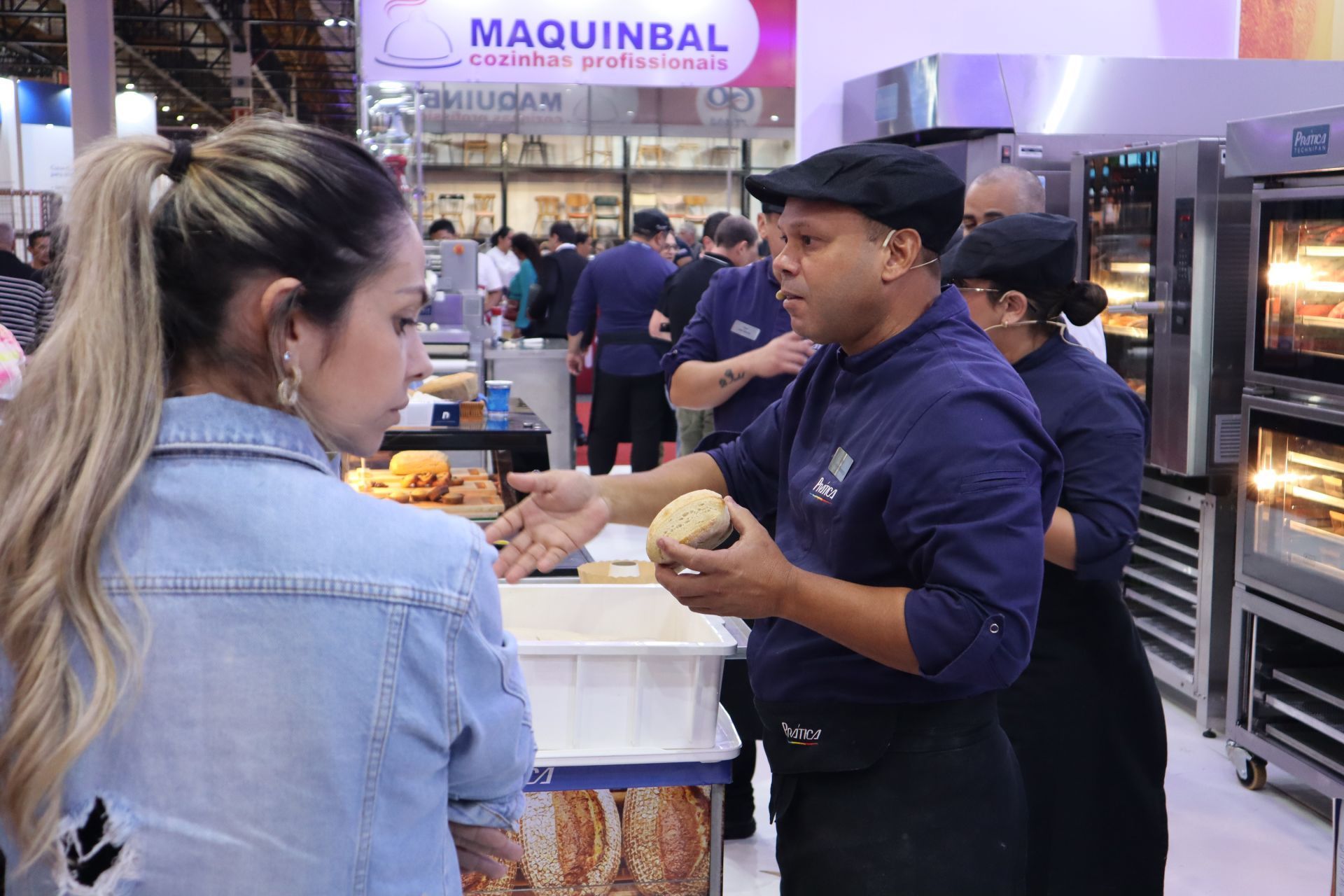 Um homem está conversando com uma mulher em uma padaria.