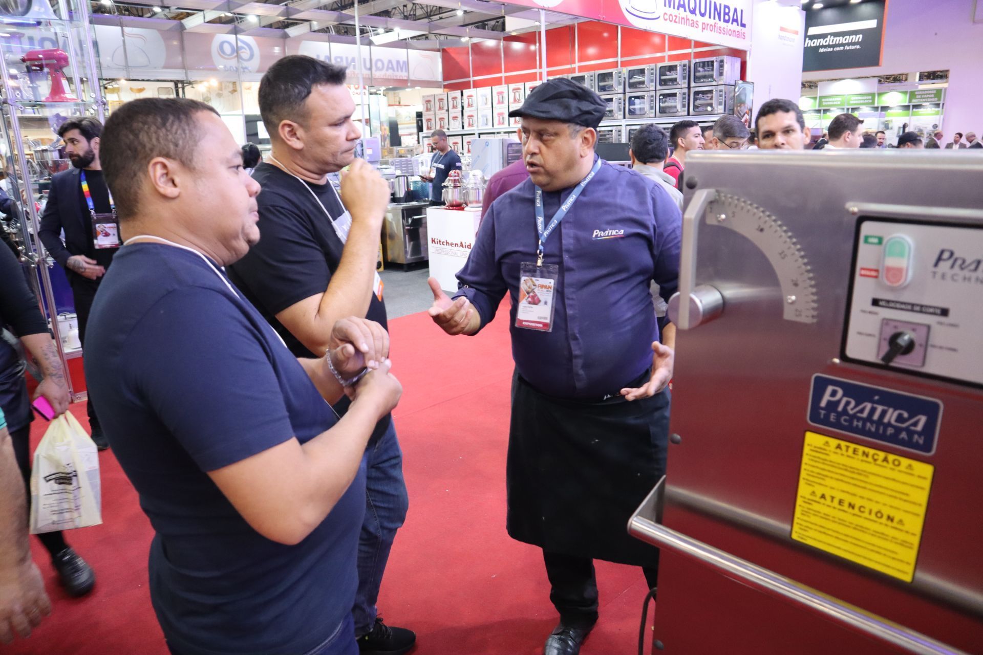 Um grupo de homens está em volta de uma máquina em uma convenção.