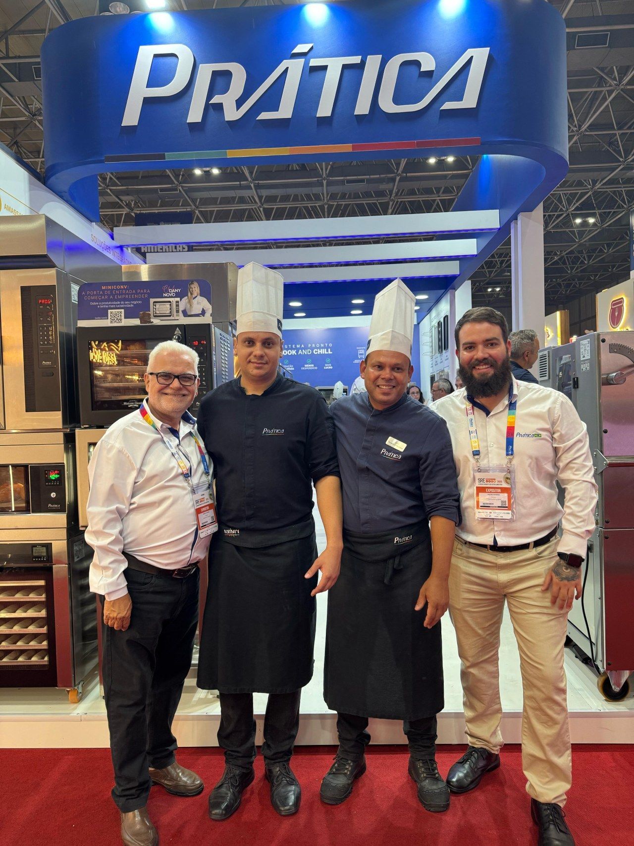 Um grupo de homens está posando para uma foto em frente a uma placa de prática.
