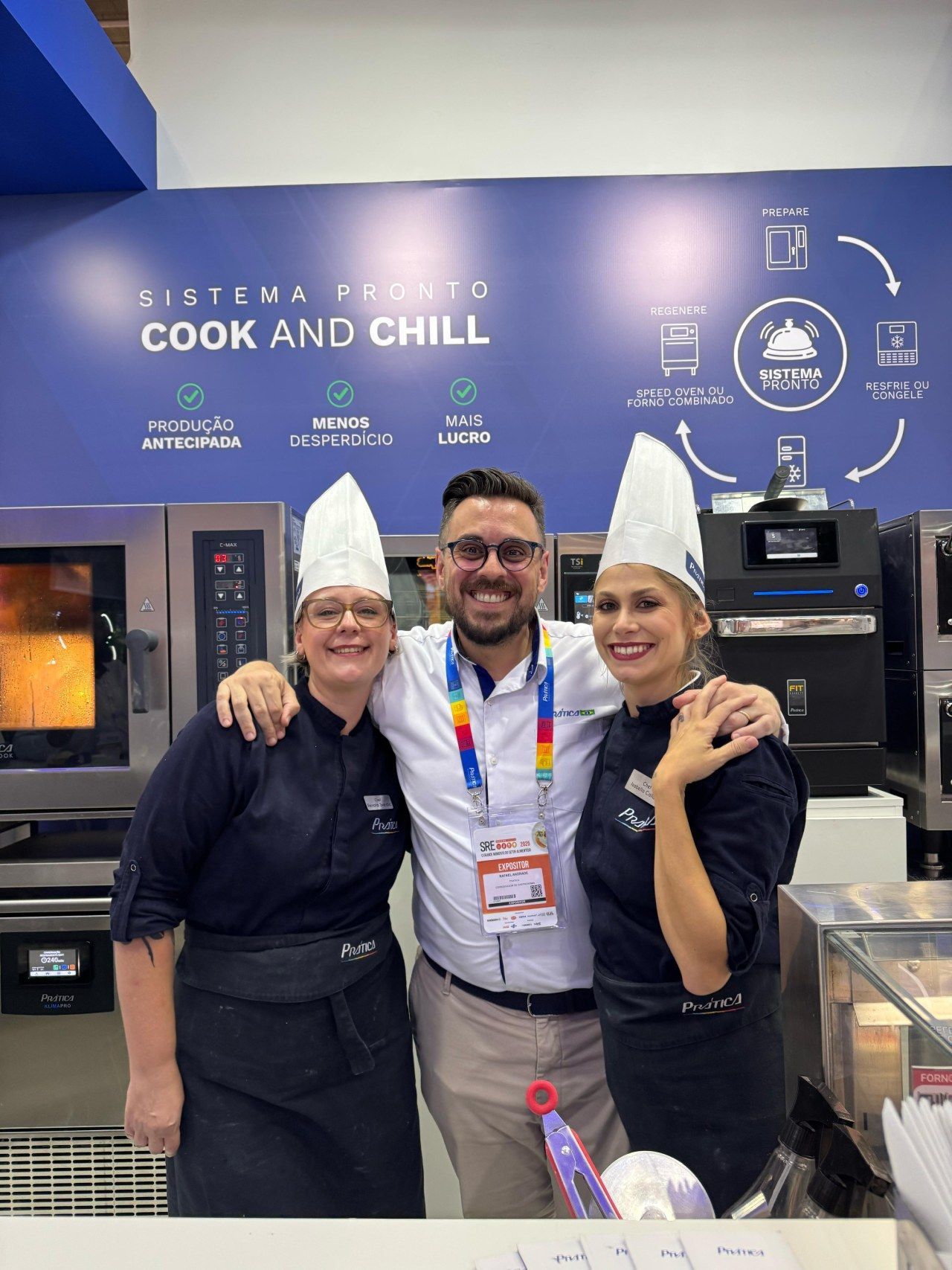 Um homem e duas mulheres estão posando para uma foto em frente a uma parede que diz cozinhe e relaxe.