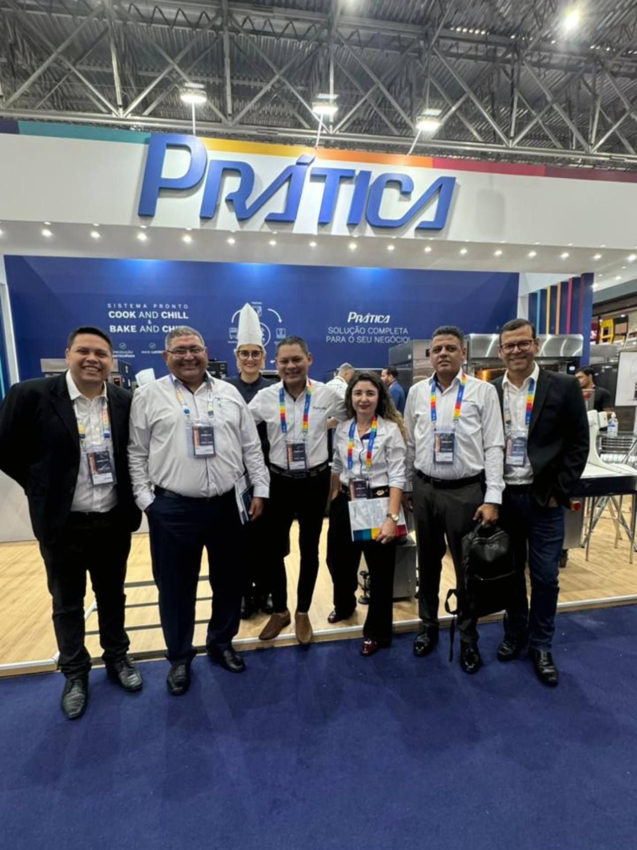 Um grupo de pessoas está posando para uma foto em frente a um estande de prática.