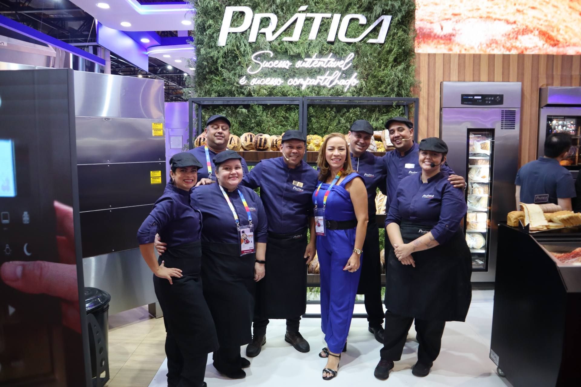 Um grupo de pessoas está posando para uma foto em uma cozinha.