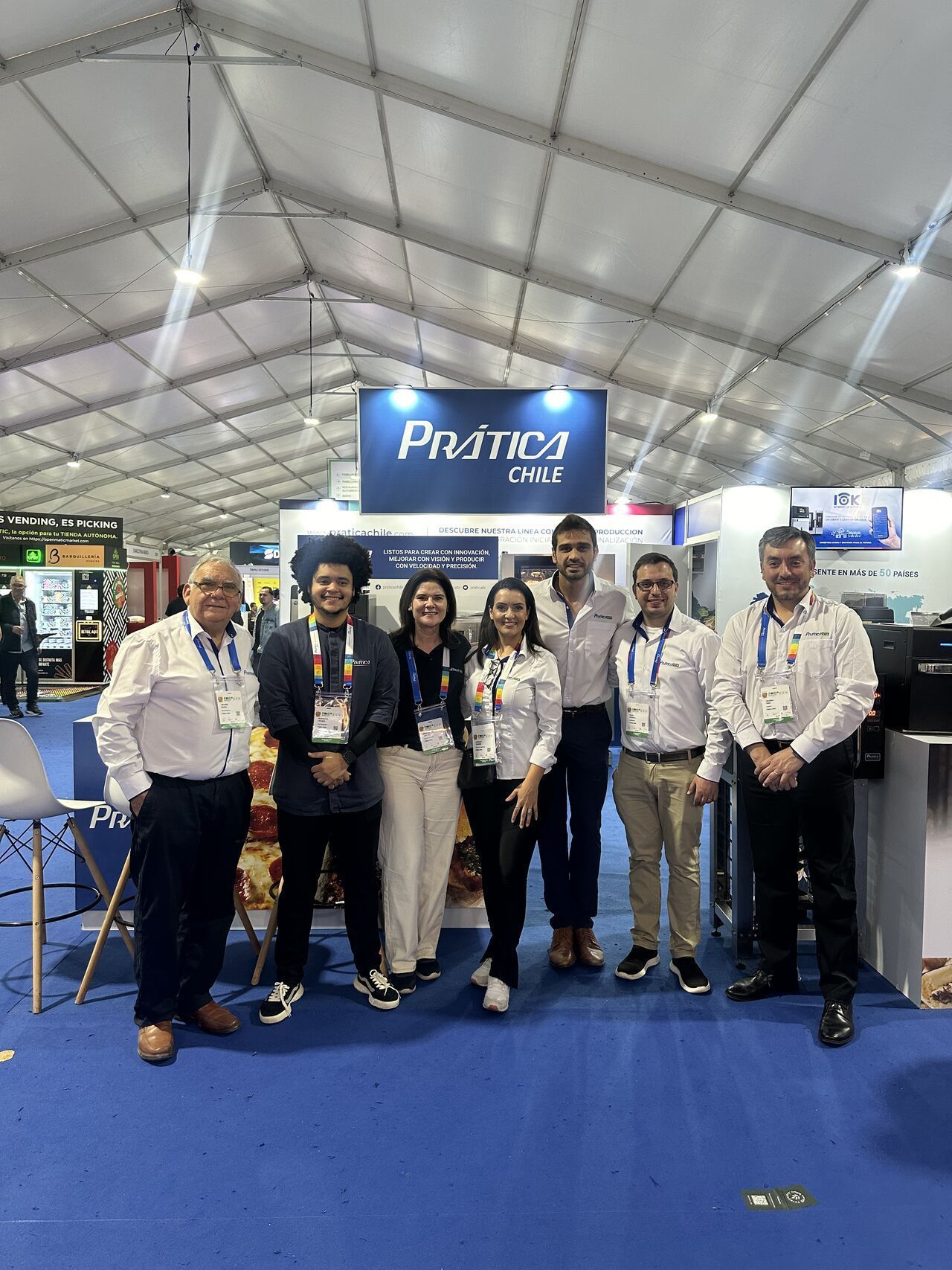 Um grupo de pessoas está posando para uma foto em uma barraca.