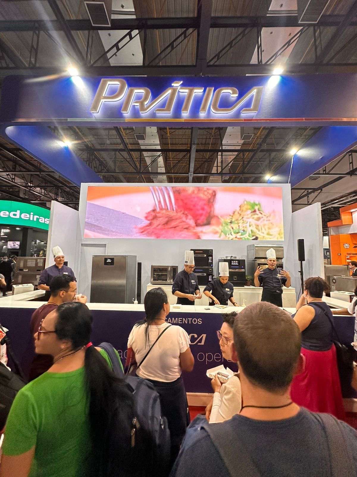 Um grupo de pessoas está em frente a uma placa que diz prática