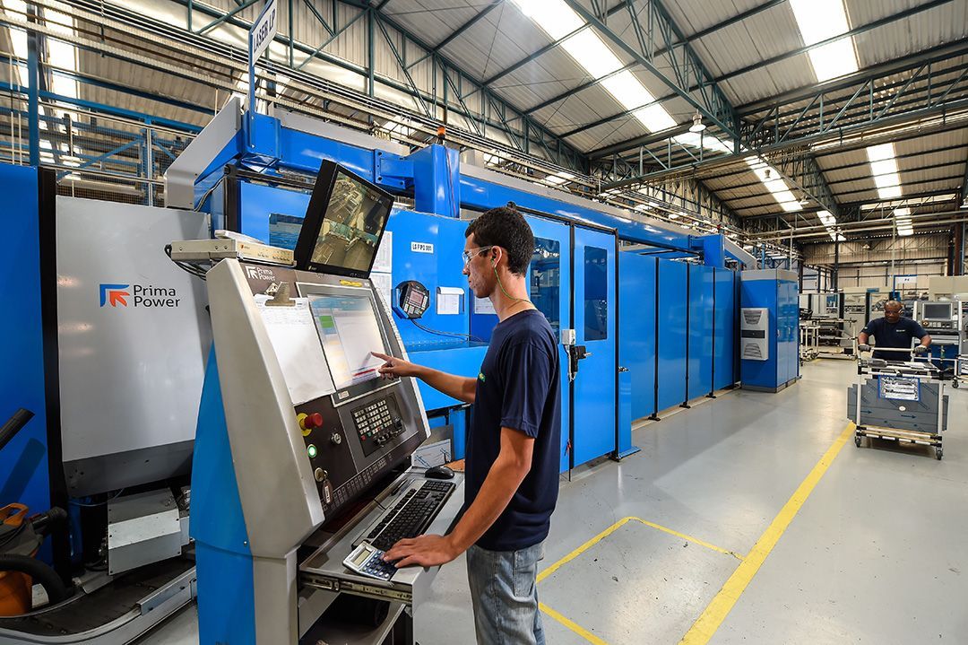 Um homem está trabalhando em uma máquina em uma fábrica.