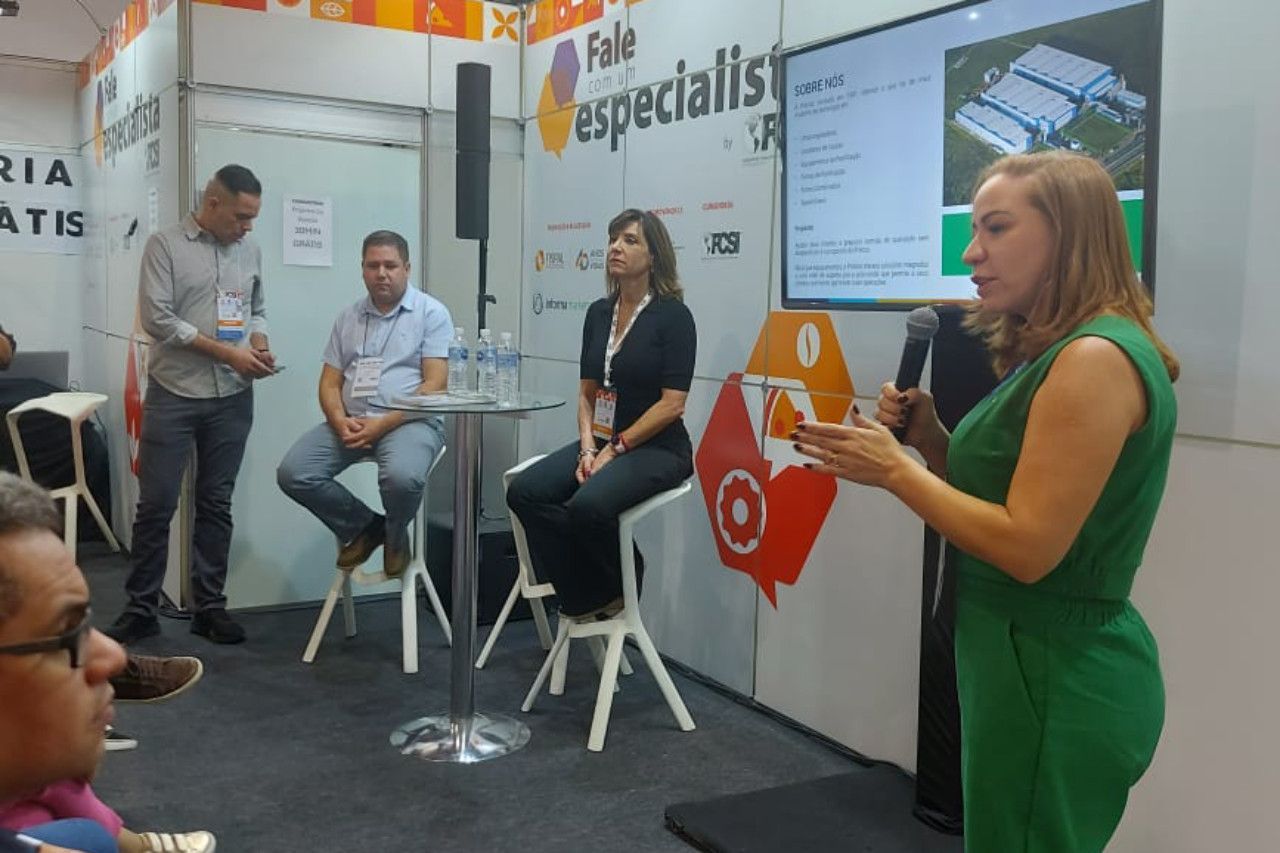 Uma mulher com um vestido verde está fazendo uma apresentação para um grupo de pessoas.