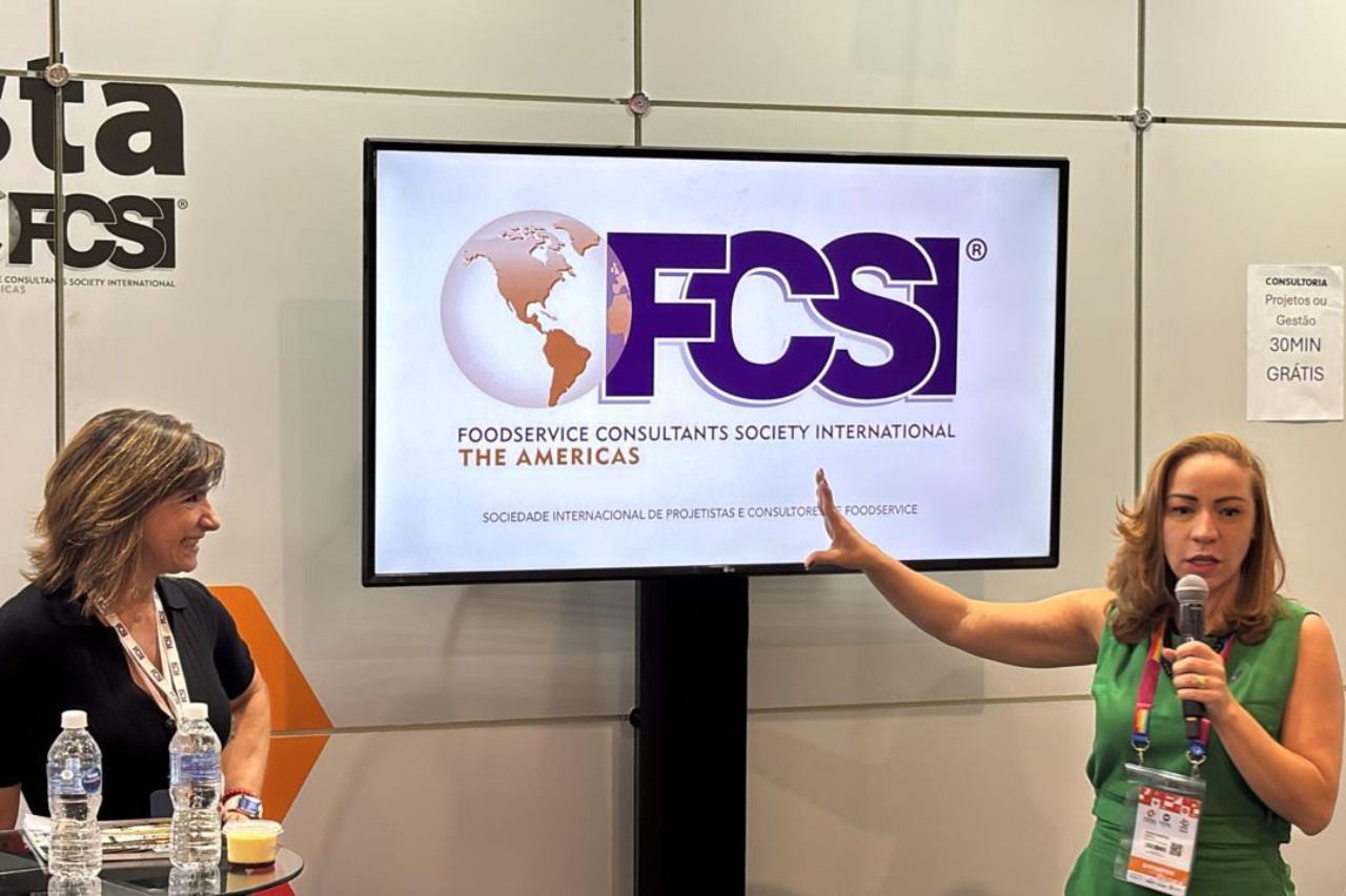 Duas mulheres estão em frente a uma tela que diz fcs