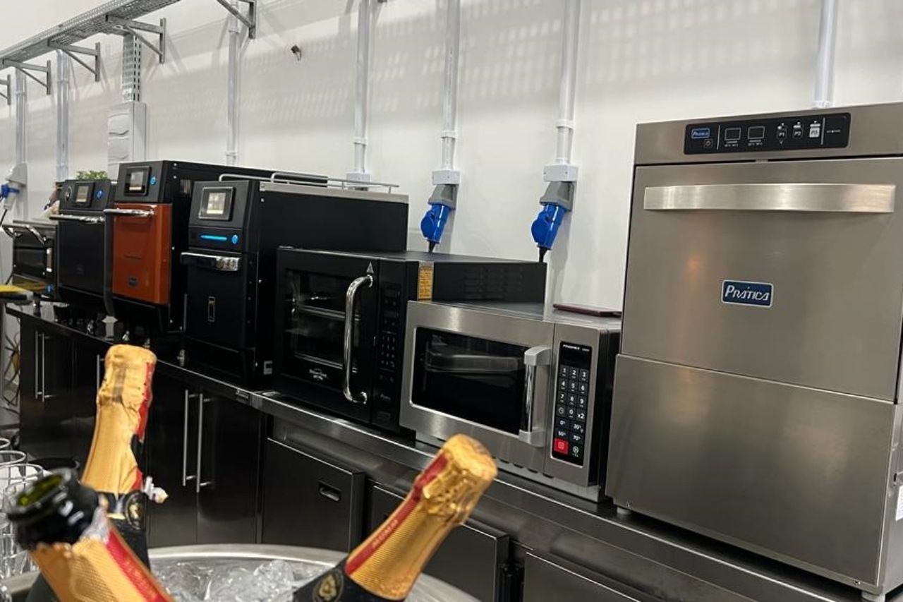 Uma cozinha com muitos eletrodomésticos e garrafas de champanhe.