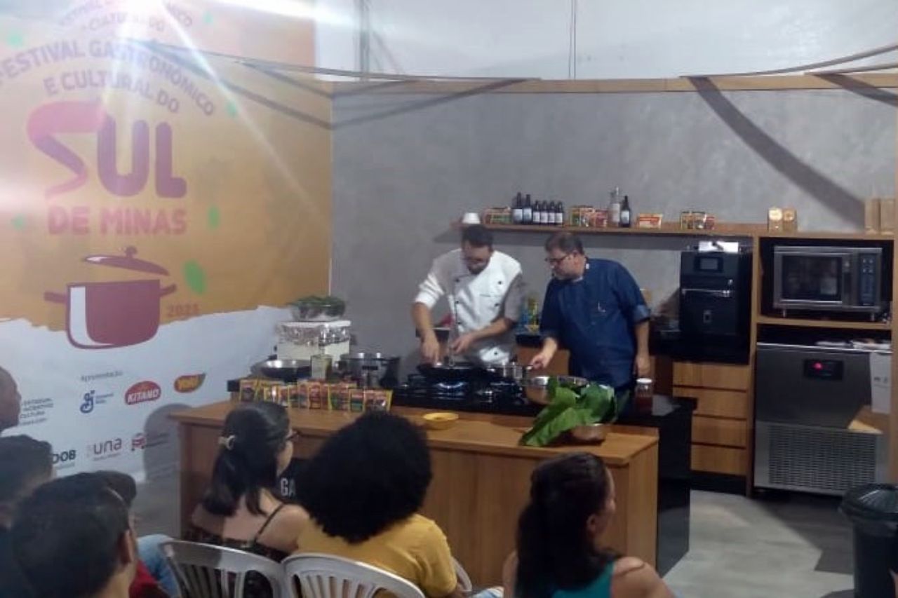 Um grupo de pessoas está sentado em cadeiras em frente a uma cozinha com uma placa que diz sul