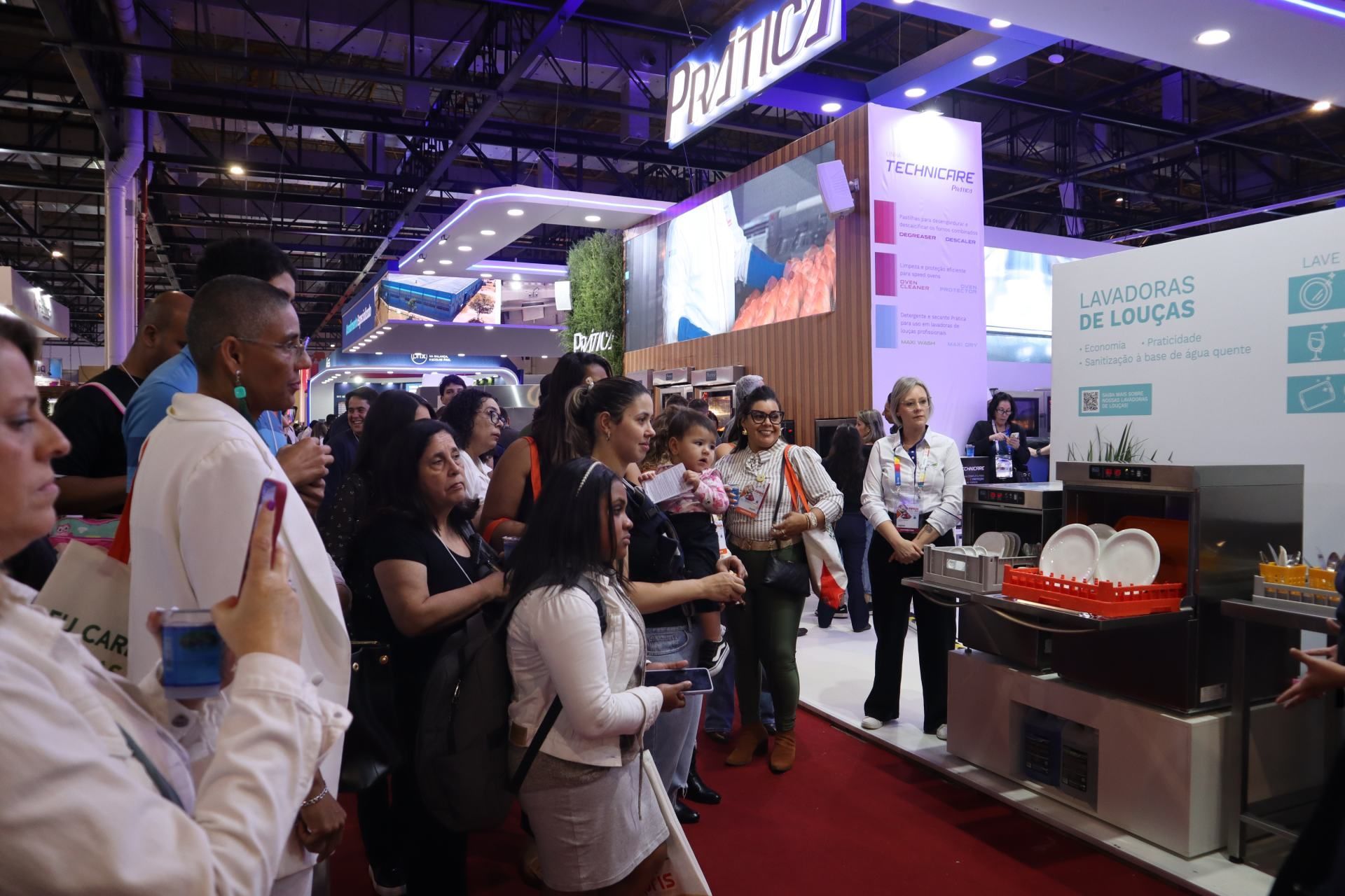 Um grupo de pessoas está em uma sala de convenção.