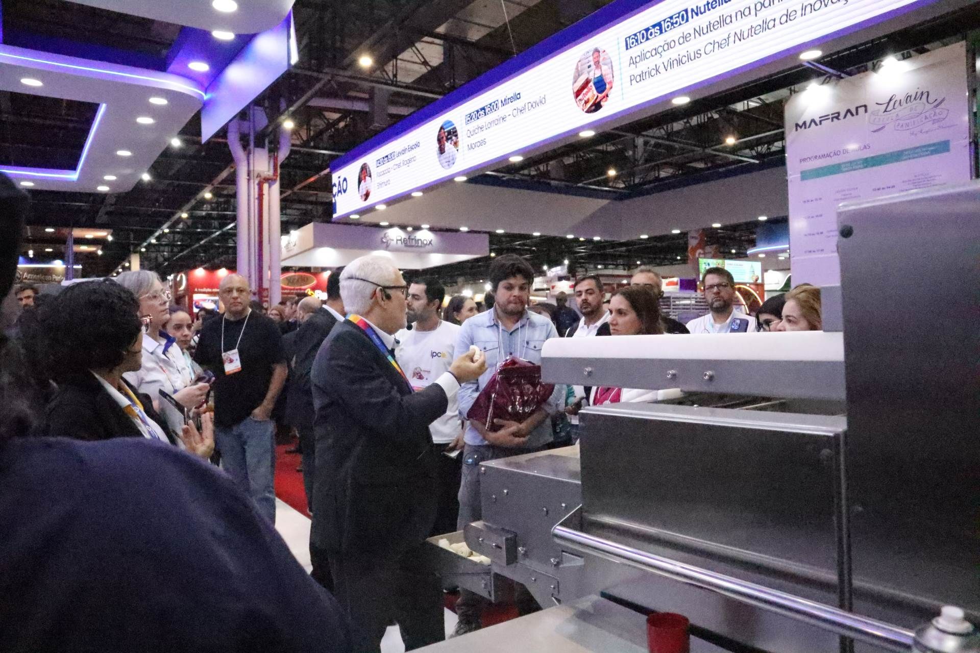 Um grupo de pessoas está ao redor de uma máquina em uma convenção.