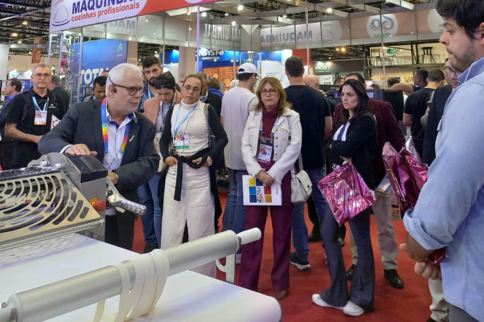 Um grupo de pessoas está ao redor de uma máquina em uma convenção.