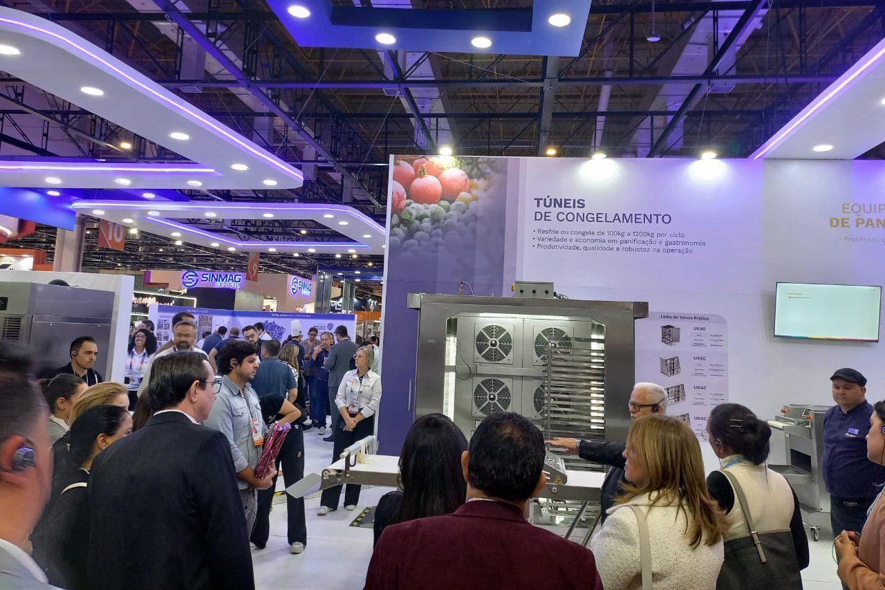 Um grupo de pessoas está em uma sala olhando para uma máquina.