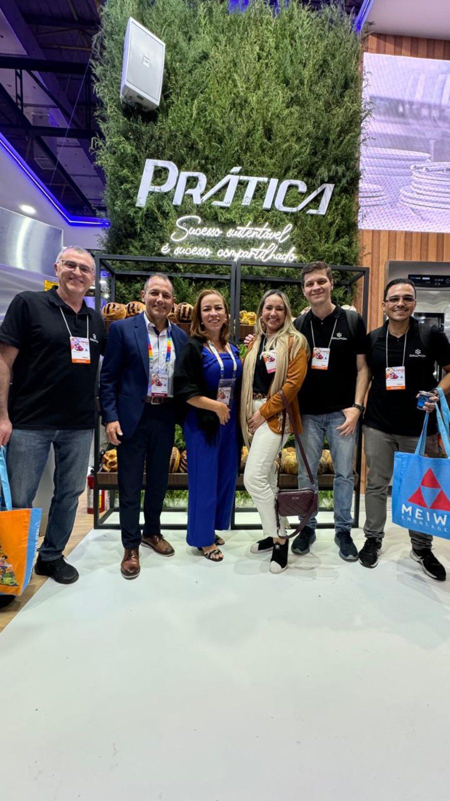 Um grupo de pessoas está posando para uma foto em uma convenção.