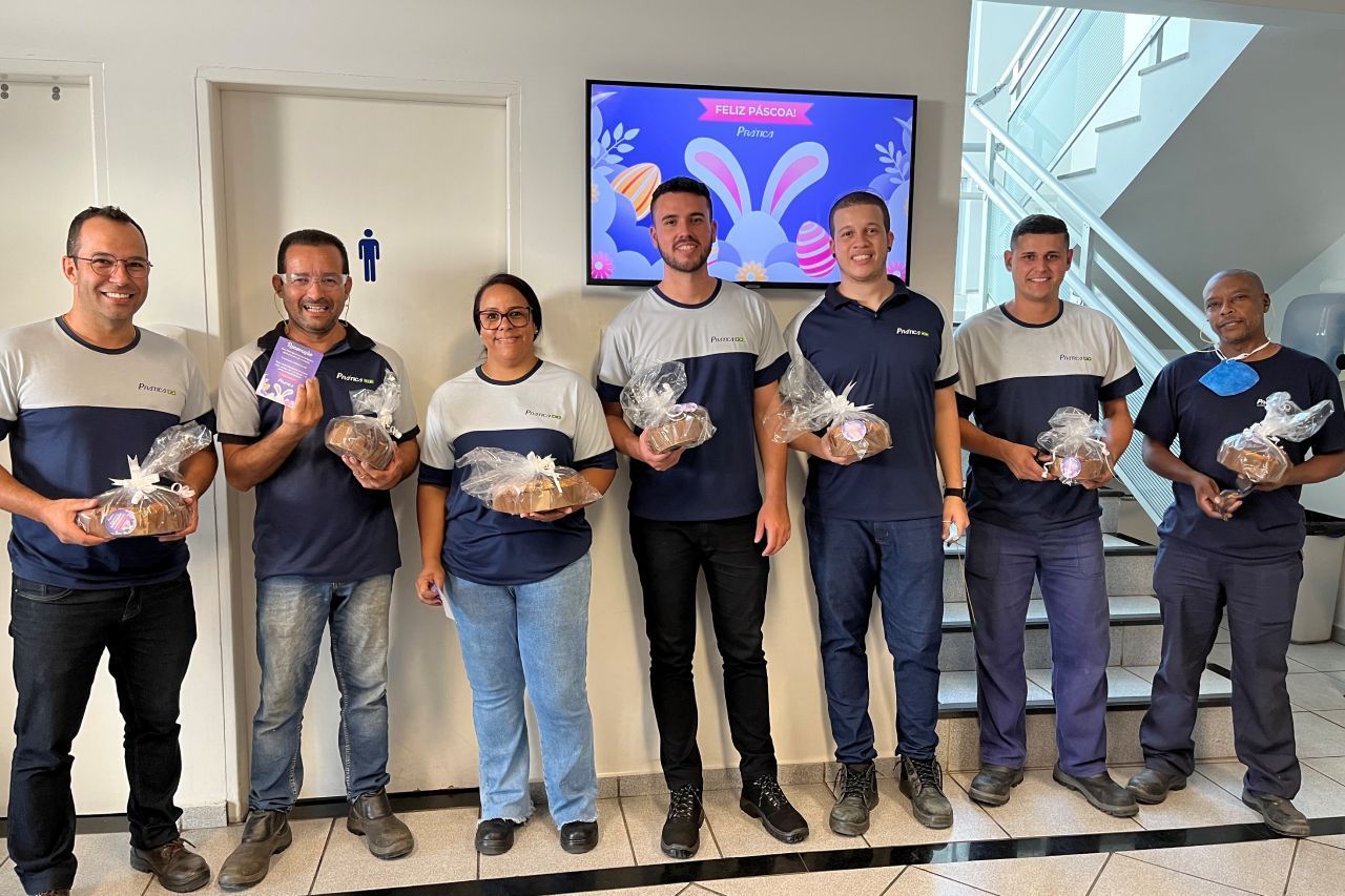 Um grupo de pessoas de pé, uma ao lado da outra, segurando ovos de Páscoa.