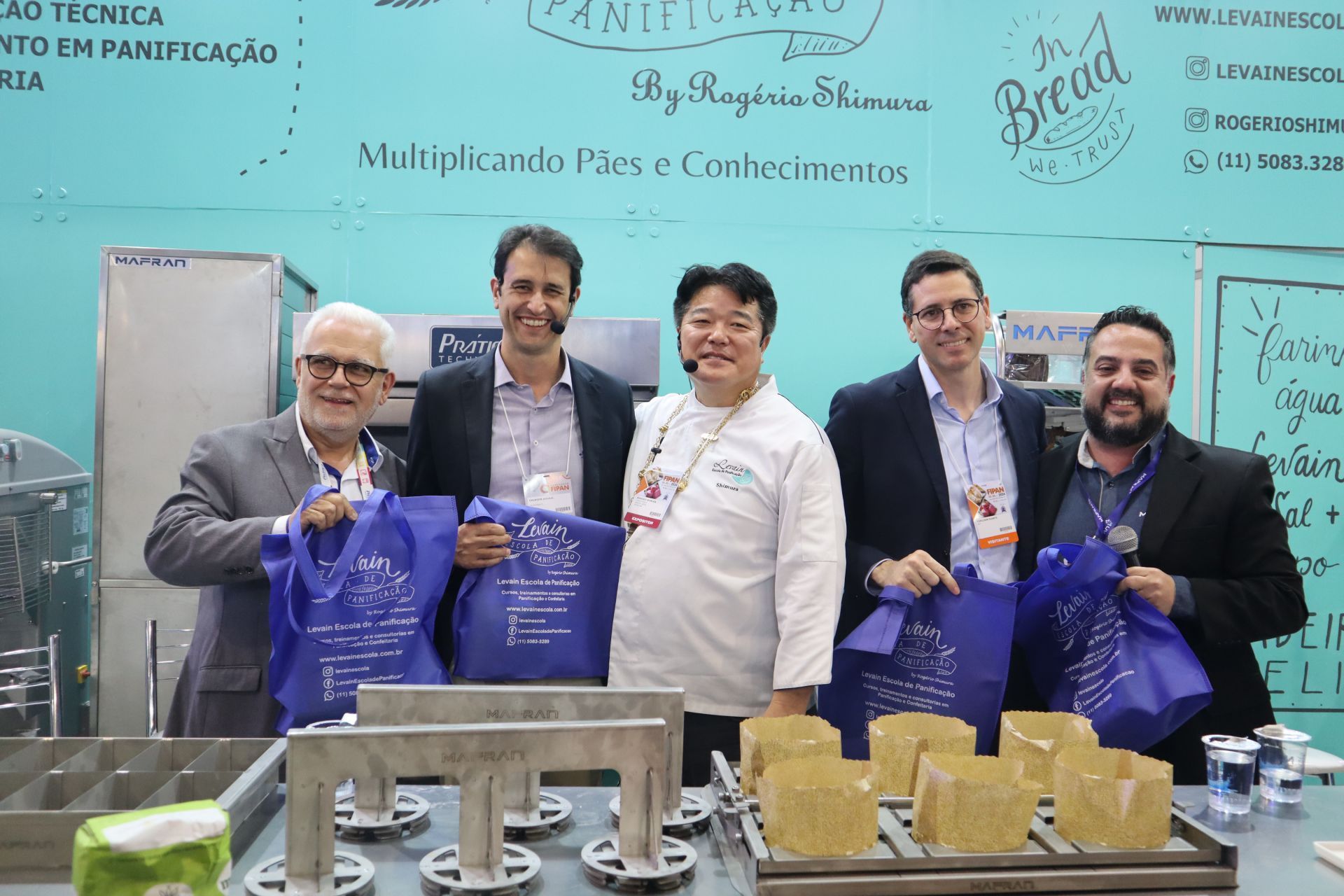 Um grupo de homens está posando para uma foto em frente a uma placa que diz pão