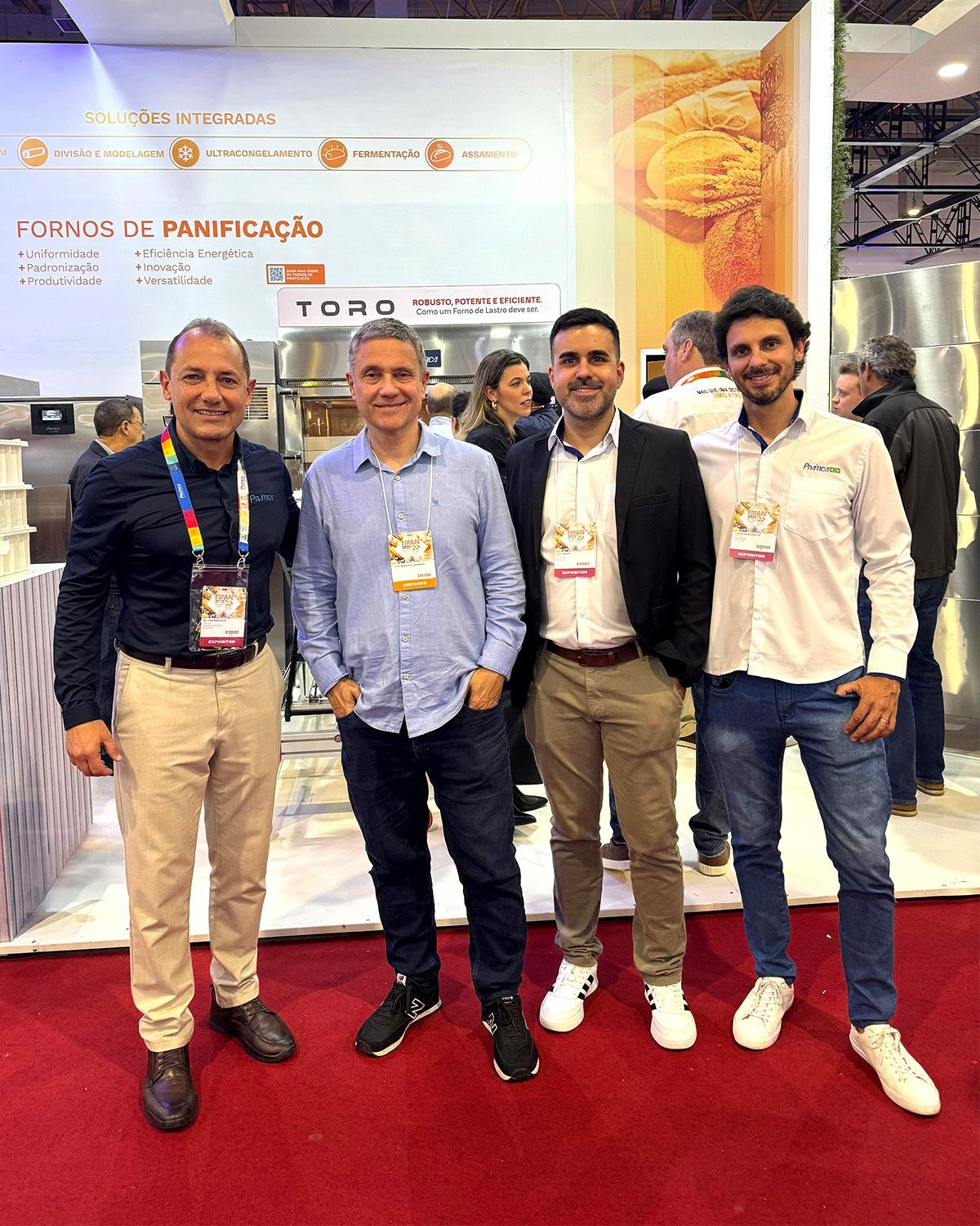 Um grupo de homens está posando para uma foto em uma convenção.