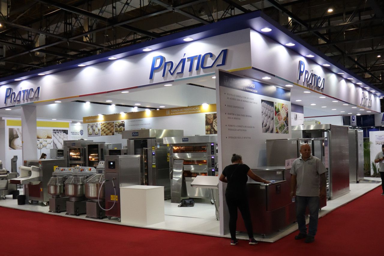 Um homem e uma mulher estão em frente a uma exposição em uma convenção.