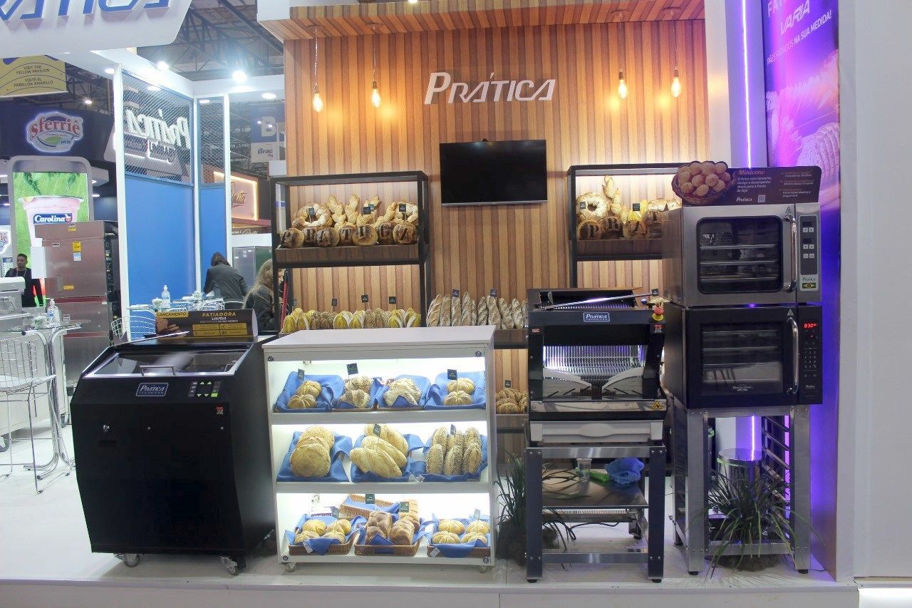 Uma exposição de padaria com muito pão nas prateleiras e fornos.