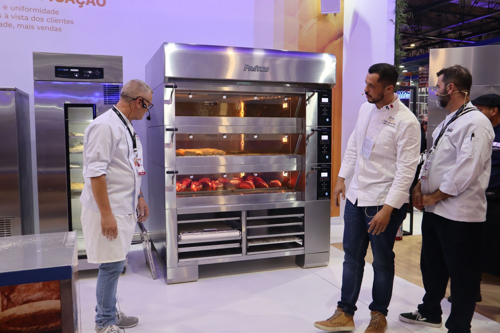 Um grupo de homens está diante de um grande forno.