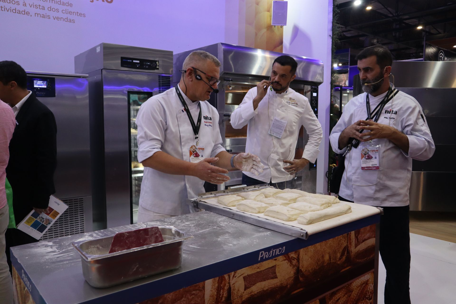 Um grupo de homens está em volta de uma mesa com comida em cima.