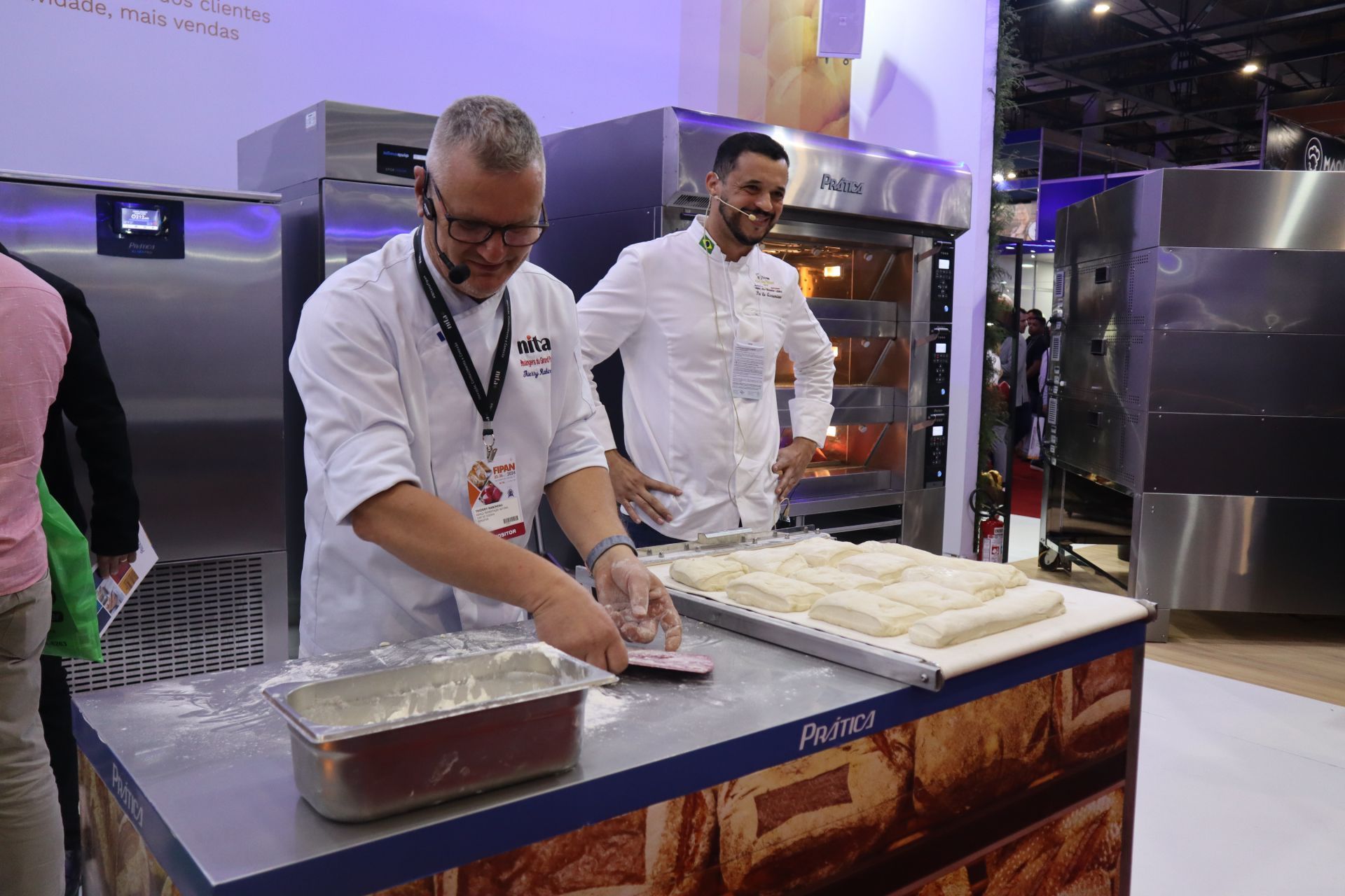 Dois homens estão um ao lado do outro em uma cozinha preparando comida.