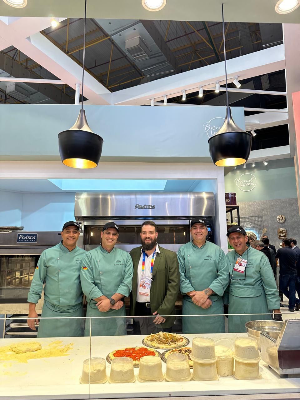 Um grupo de chefs está posando para uma foto em uma cozinha.